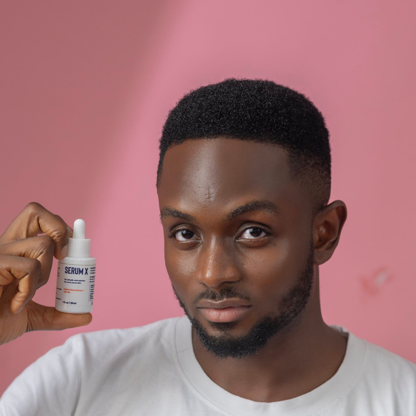 Image of a male model holding up a TNS skincare product